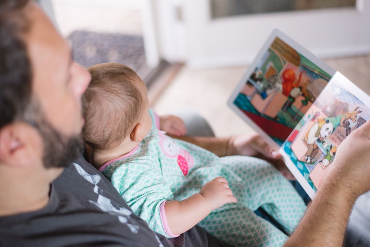 Man sitting and reading to a baby on his lap